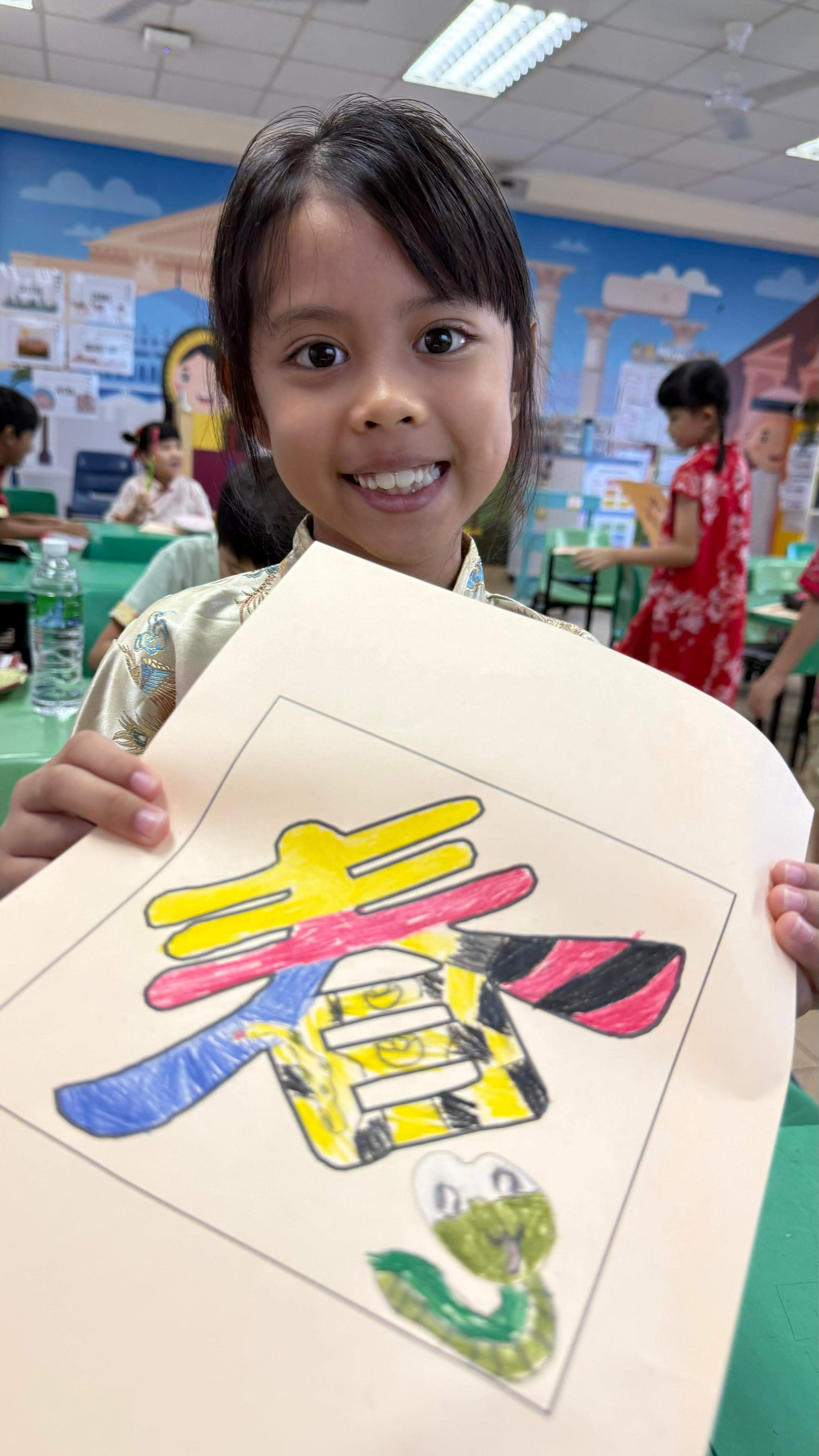 A student showcasing their colouring work for the word art- spring